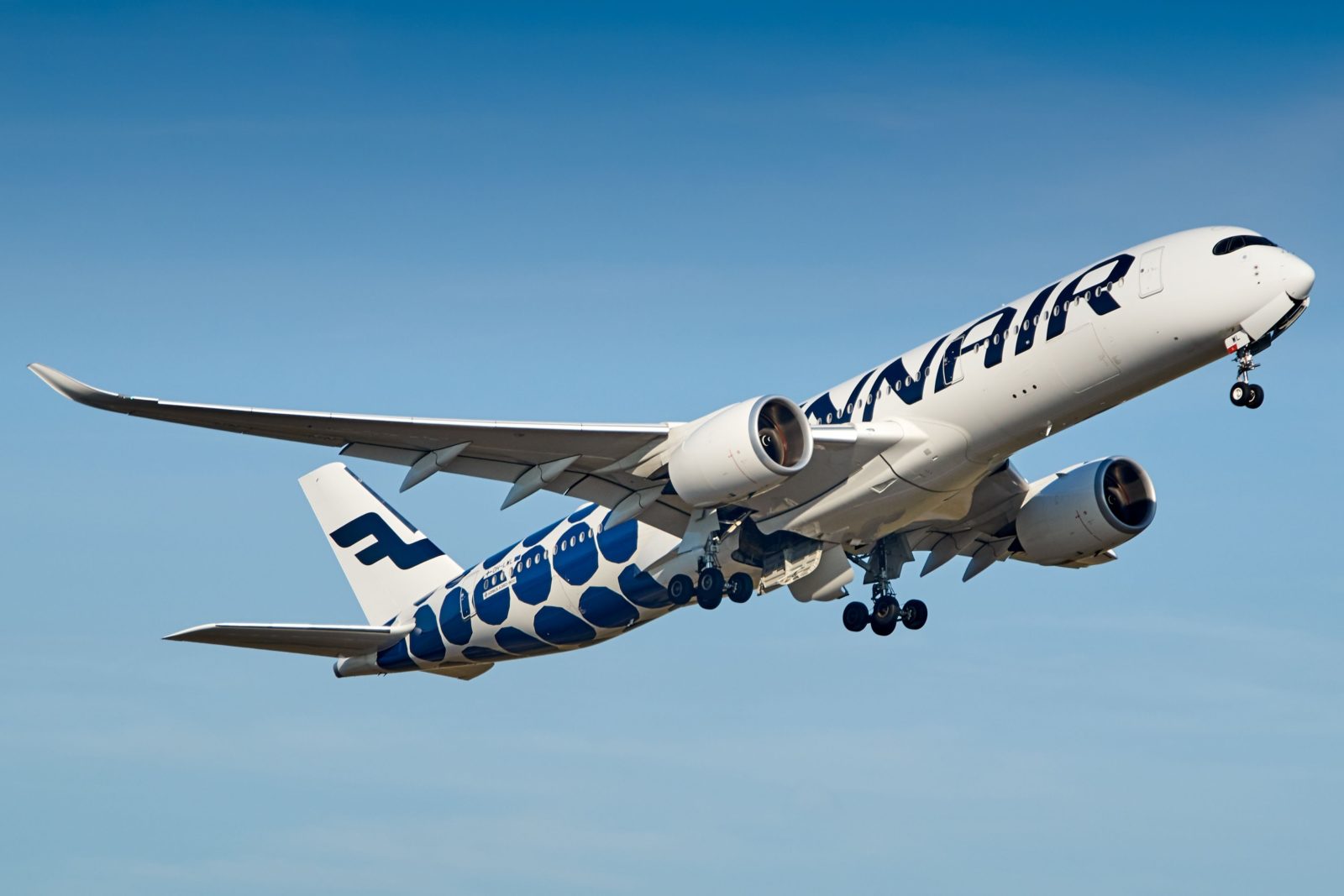 a white and blue airplane flying in the sky