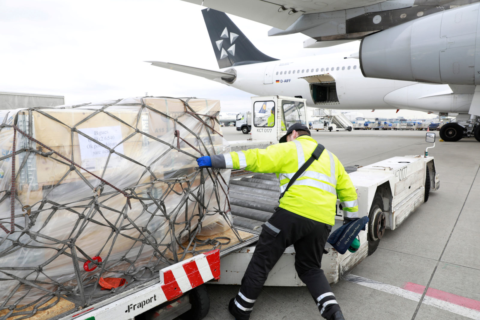 a man pushing a truck with a large object on it