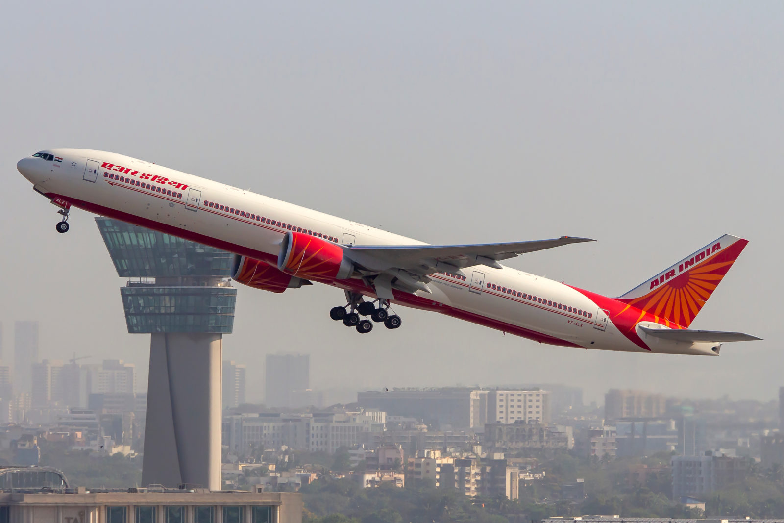 a large airplane flying over a city