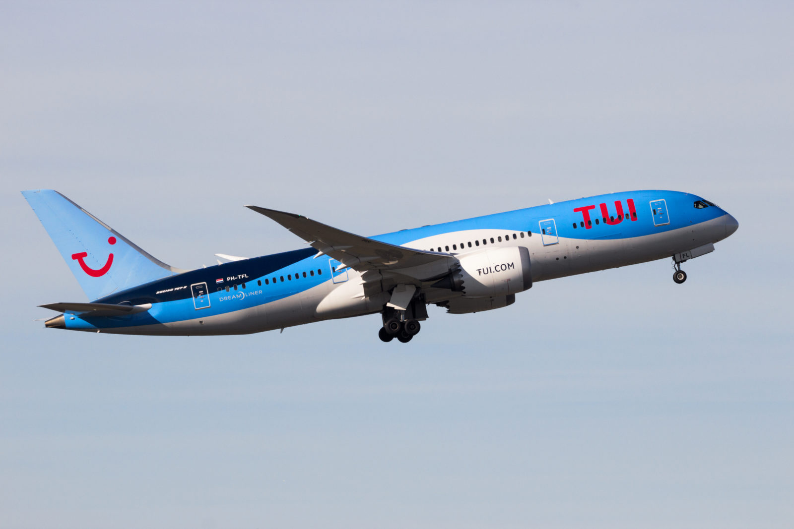 a blue and white airplane in the sky