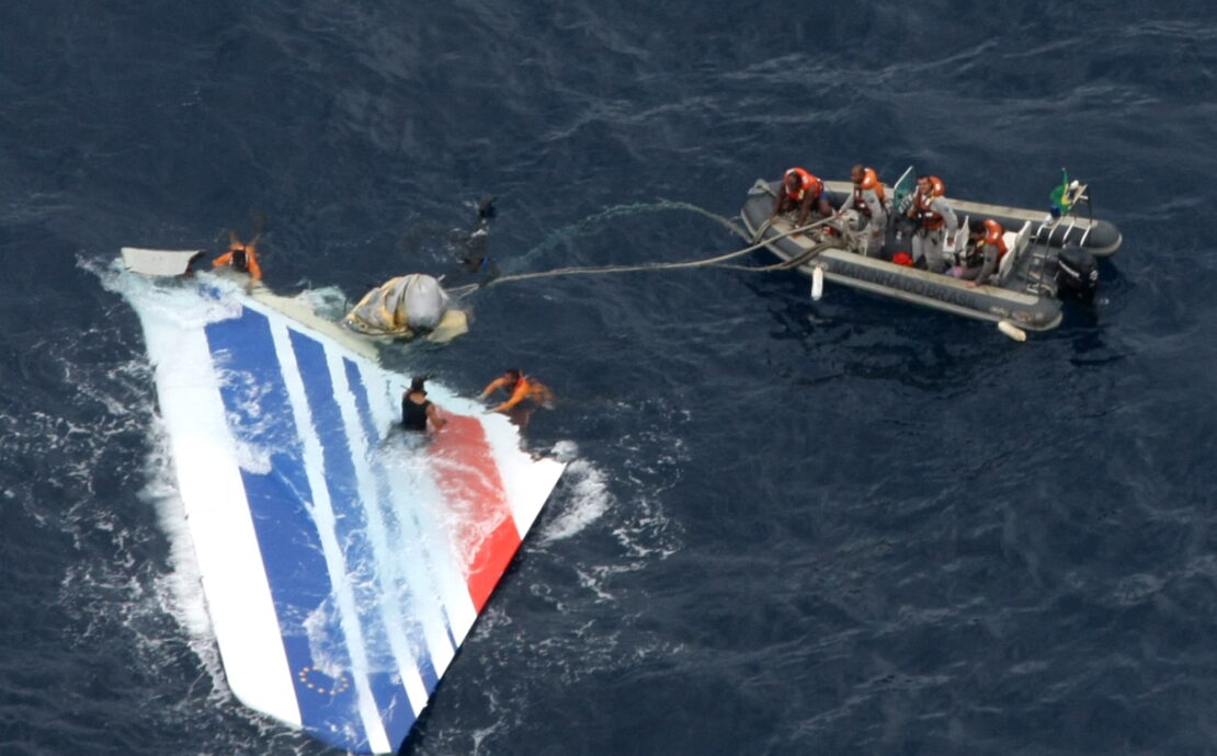 a group of people in an inflatable boat with a plane in the water
