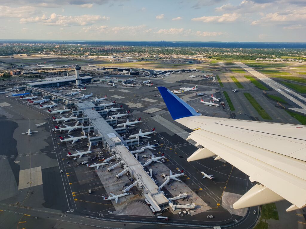 an airplane wing and a runway with many airplanes