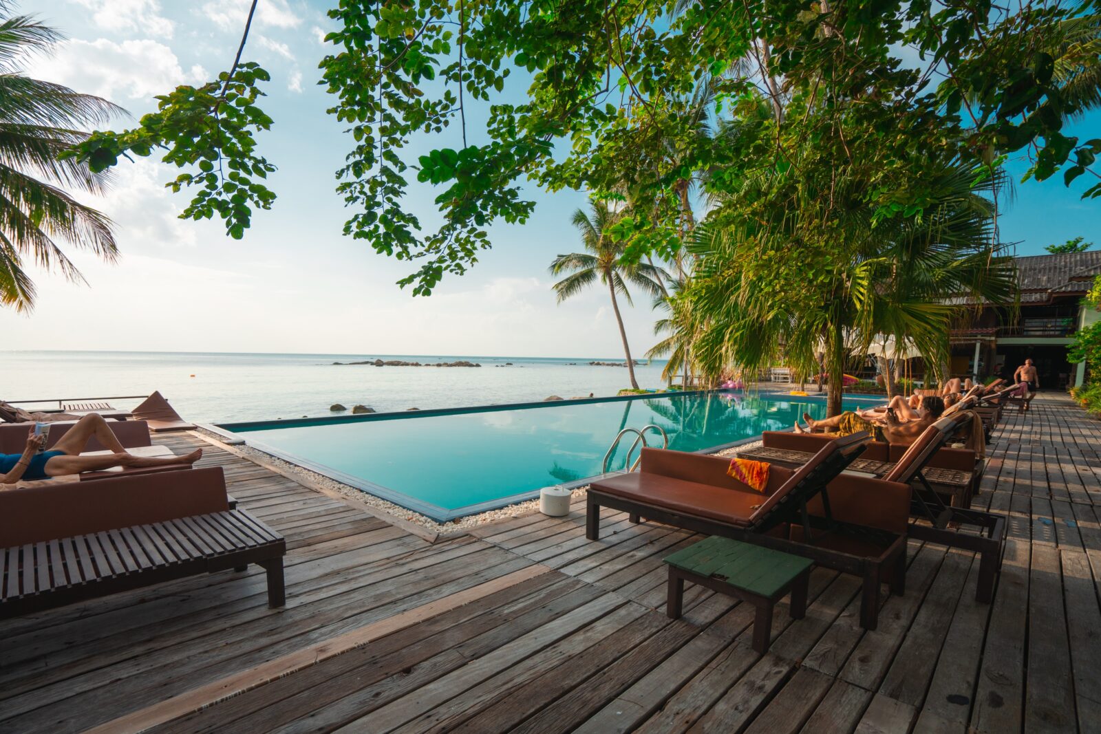a pool with chairs and trees around it