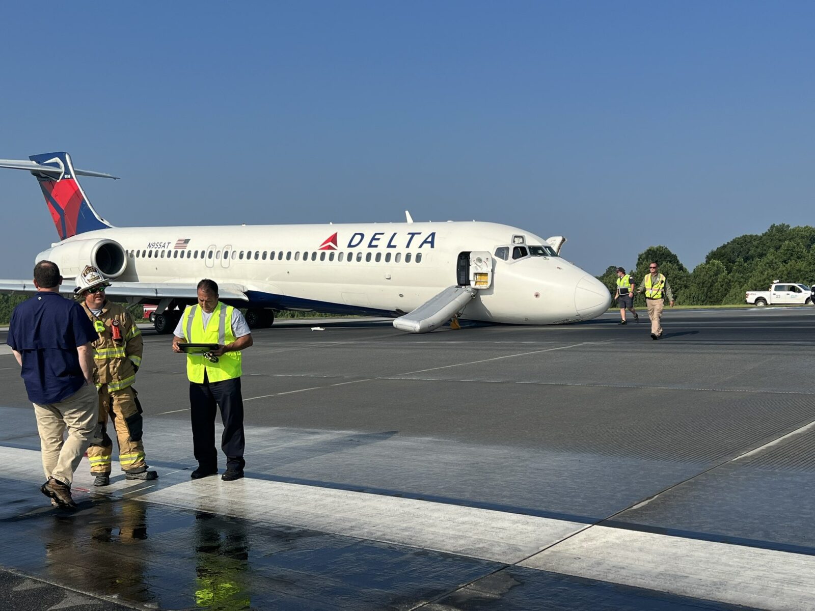 a group of people standing next to a plane