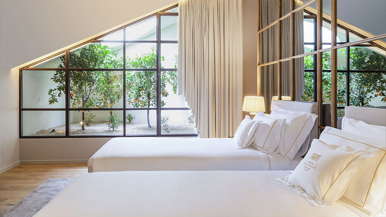 two beds in a room with a window