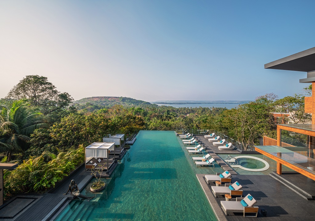 a pool with chairs and a building in the background