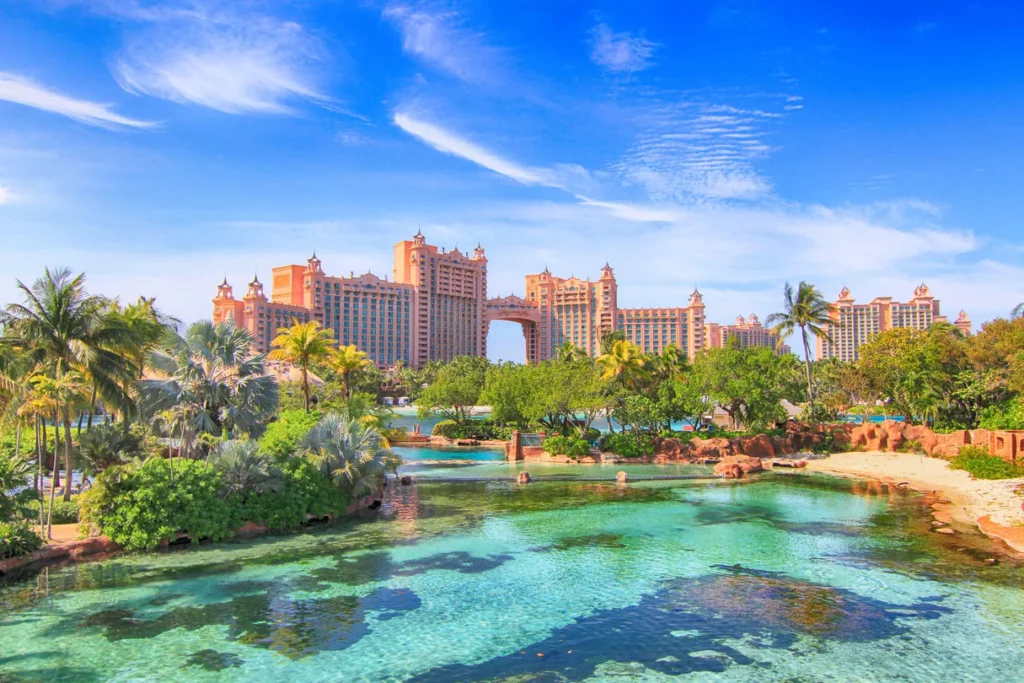 a large building with trees and a body of water with Atlantis Paradise Island in the background