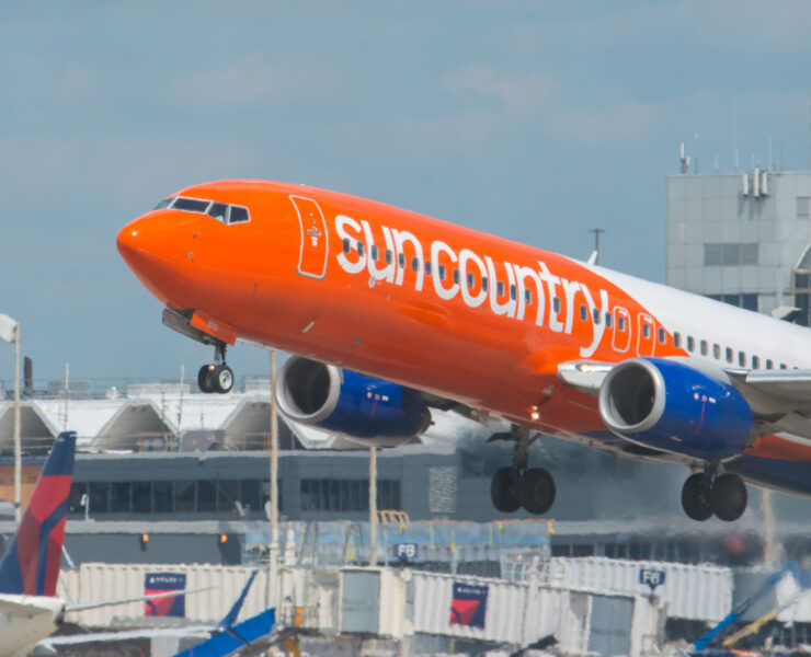an orange and white airplane taking off