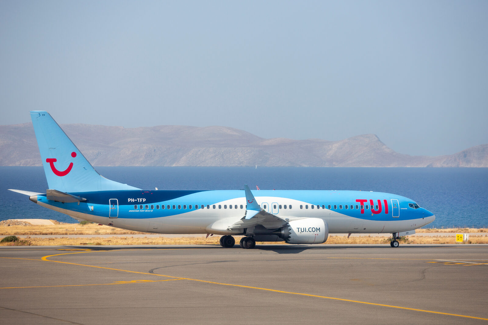 a blue and white airplane on a runway