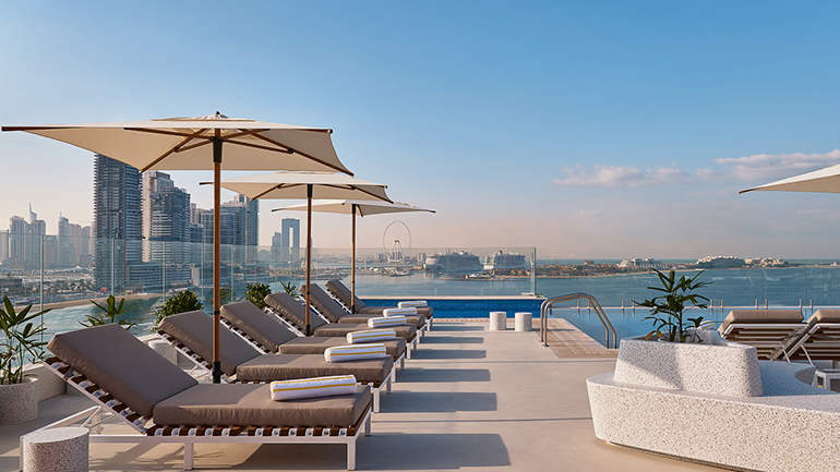 a pool with umbrellas and chairs on a rooftop