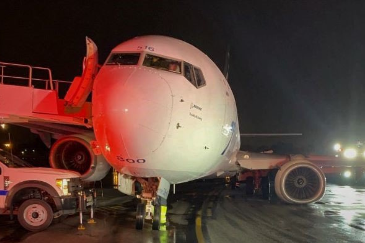 a large white airplane on a runway at night