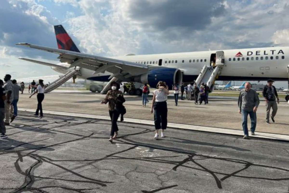 people walking on a runway with a plane