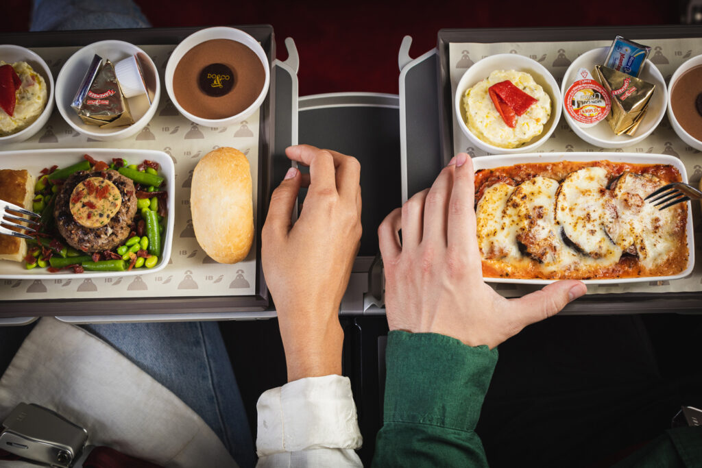 a couple of hands holding trays of food