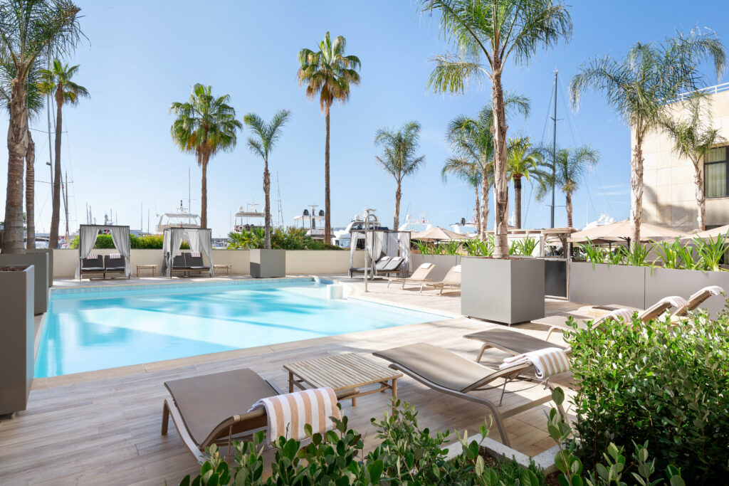 a pool with lounge chairs and palm trees