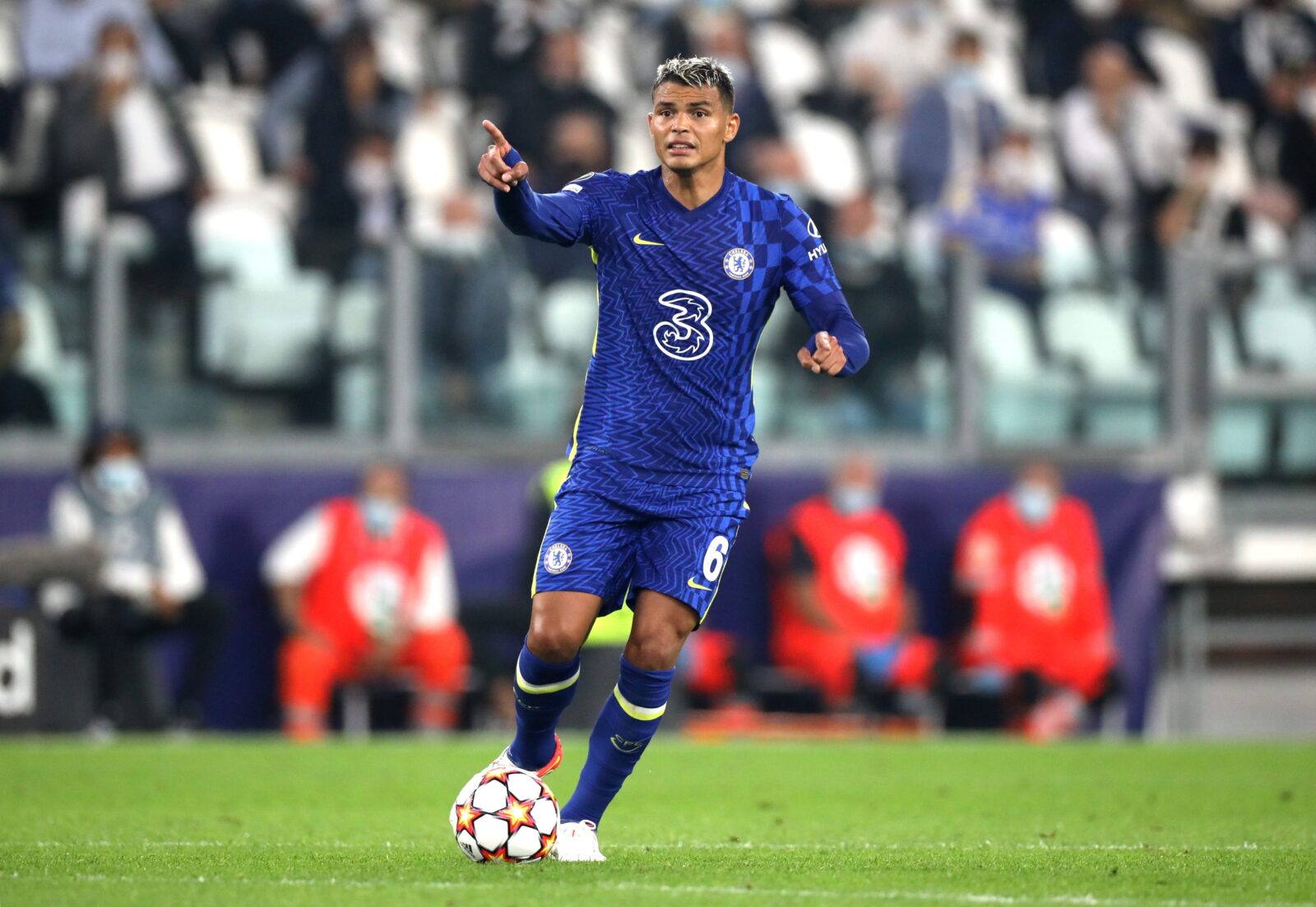 a man in a blue uniform with a ball pointing