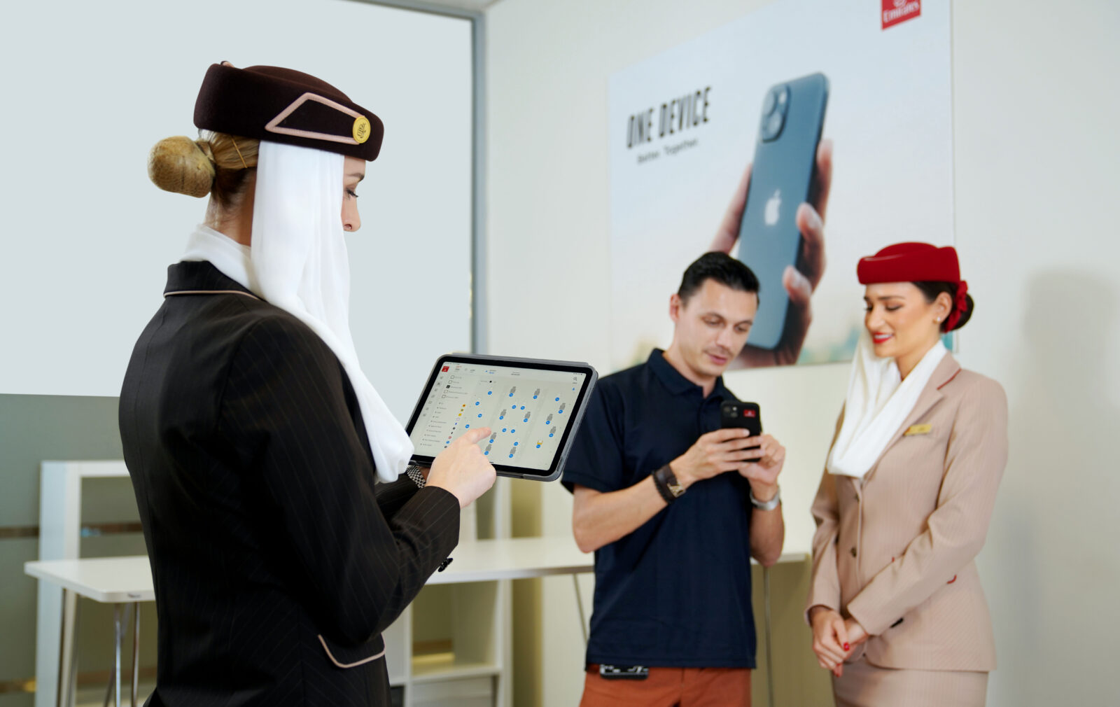 a woman in a black suit holding a tablet with a man in a hat