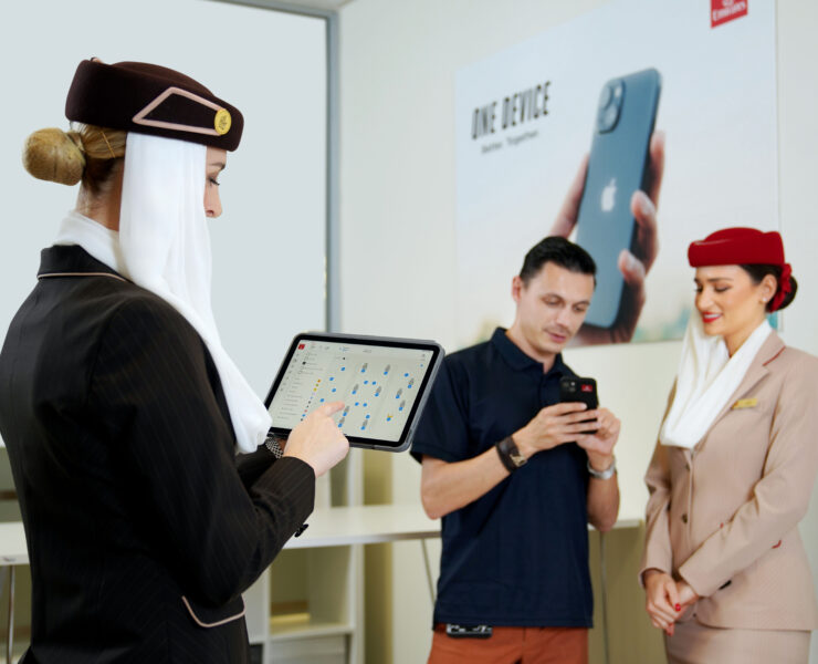 a woman in a black suit holding a tablet with a man in a hat