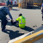 a man sitting on the ground with a man in a safety vest