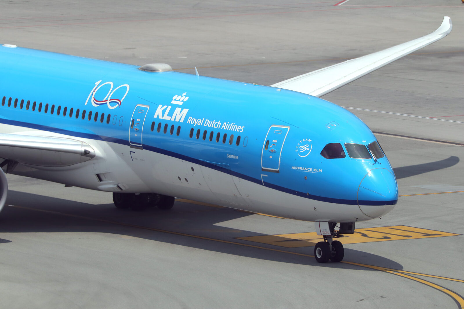 a blue and white airplane on a runway