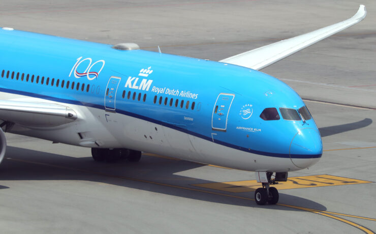a blue and white airplane on a runway