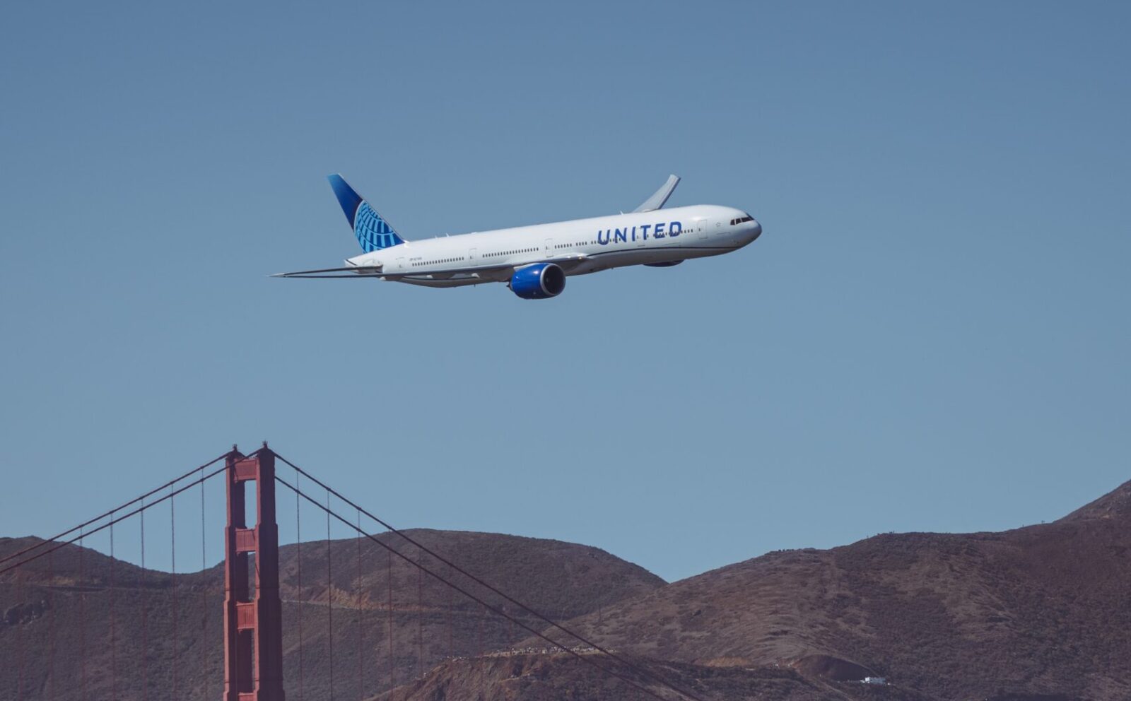 a plane flying over a bridge