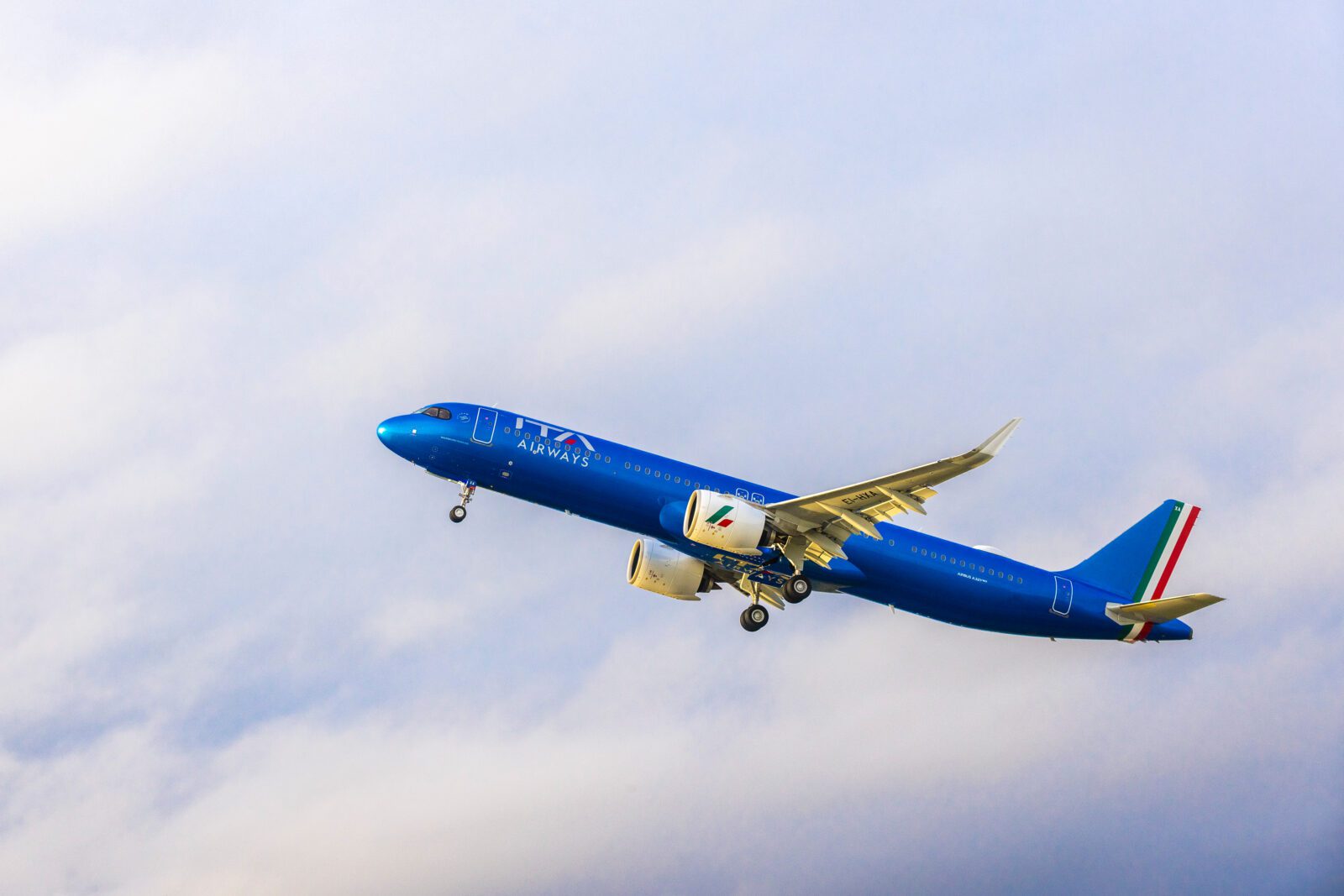 a blue airplane flying in the sky