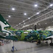 a green and white airplane in a hangar