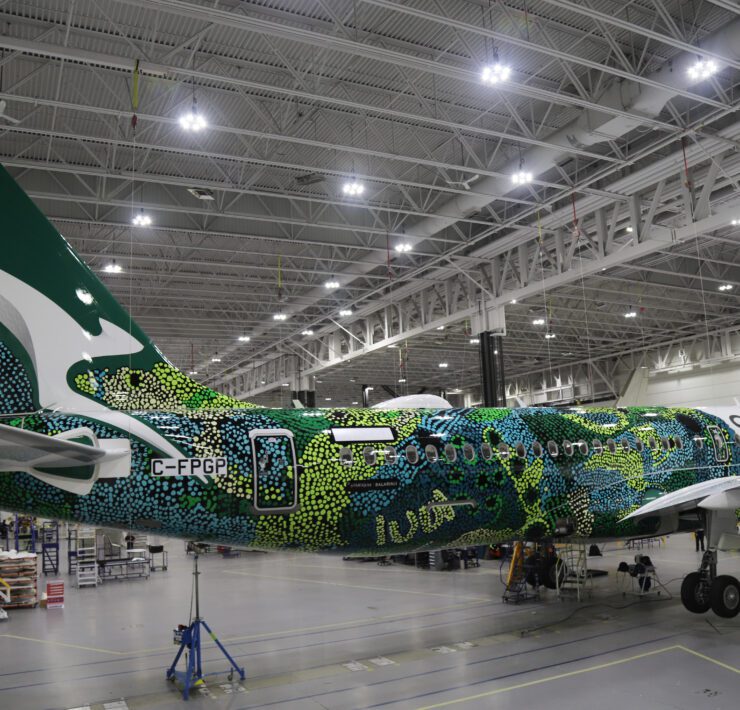 a green and white airplane in a hangar