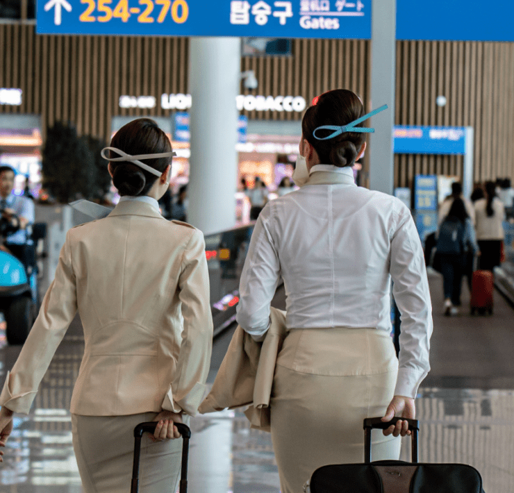 two women in uniform with luggage