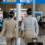 two women in uniform with luggage