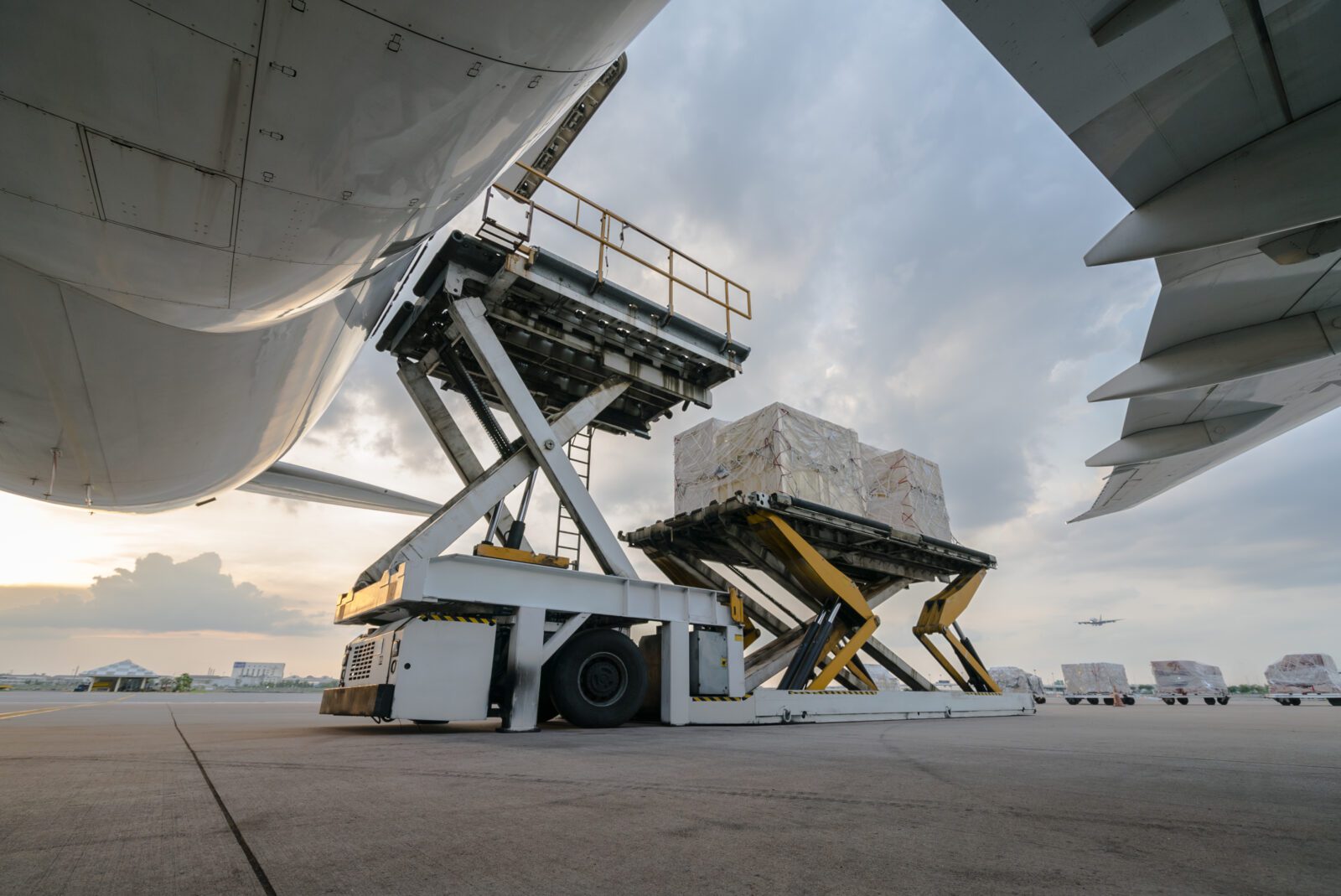 a truck loading boxes into an airplane