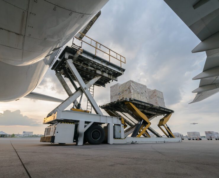 a truck loading boxes into an airplane