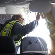 a man in a vest and glasses working on a plane