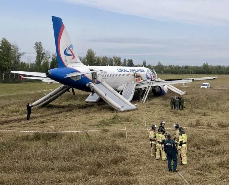 a plane on the ground with people standing around