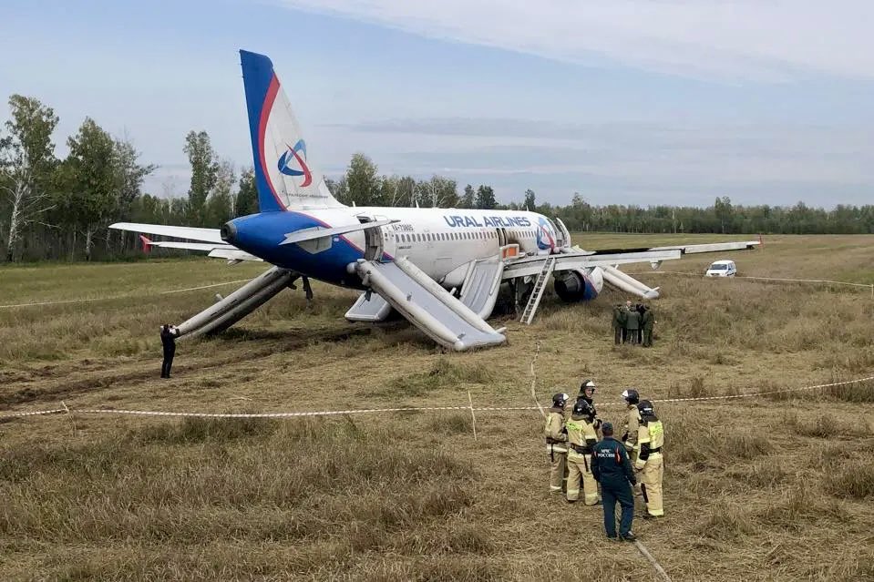 a plane on the ground with people standing around