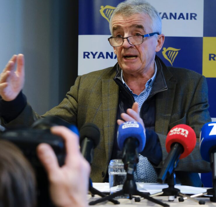 a man in a suit speaking into microphones