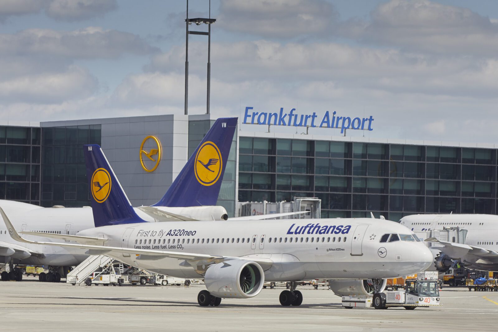 a white airplane with blue tail and yellow logo