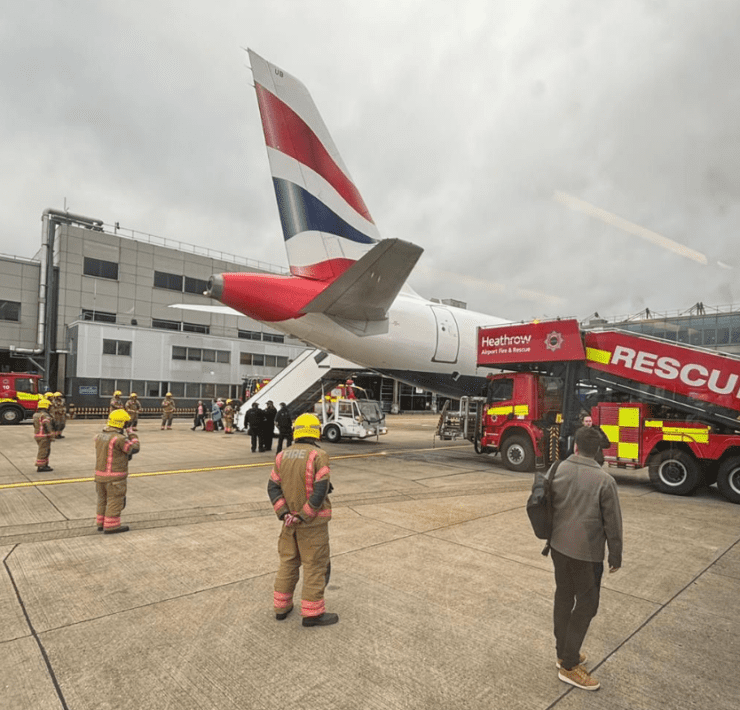 a group of people standing next to a plane