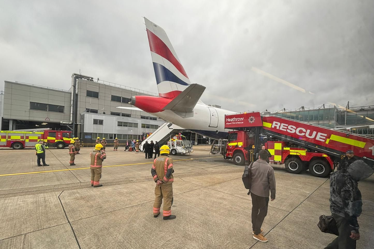 a group of people standing next to a plane