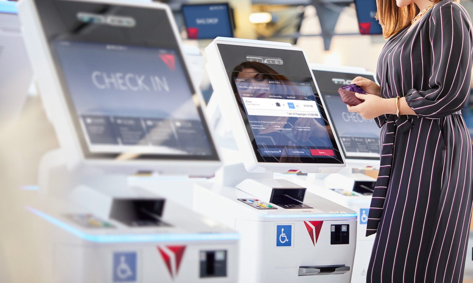 a woman standing in front of a check in machine