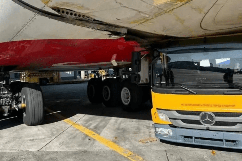 a large truck parked under a large plane
