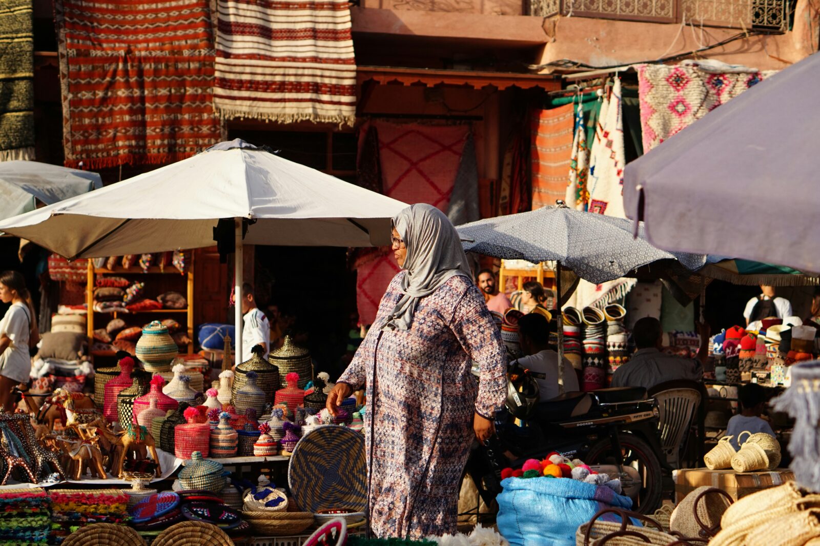 a woman in a dress walking in a market