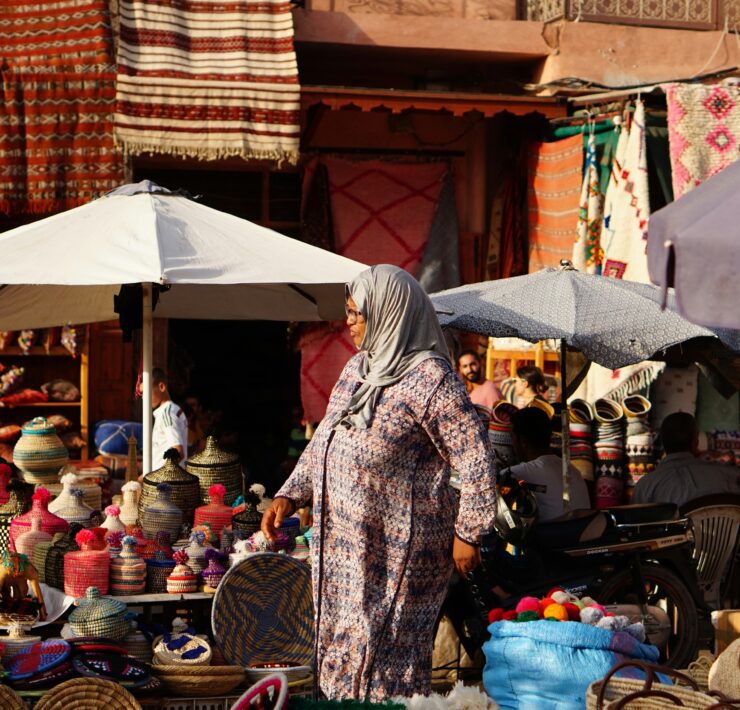 a woman in a dress walking in a market