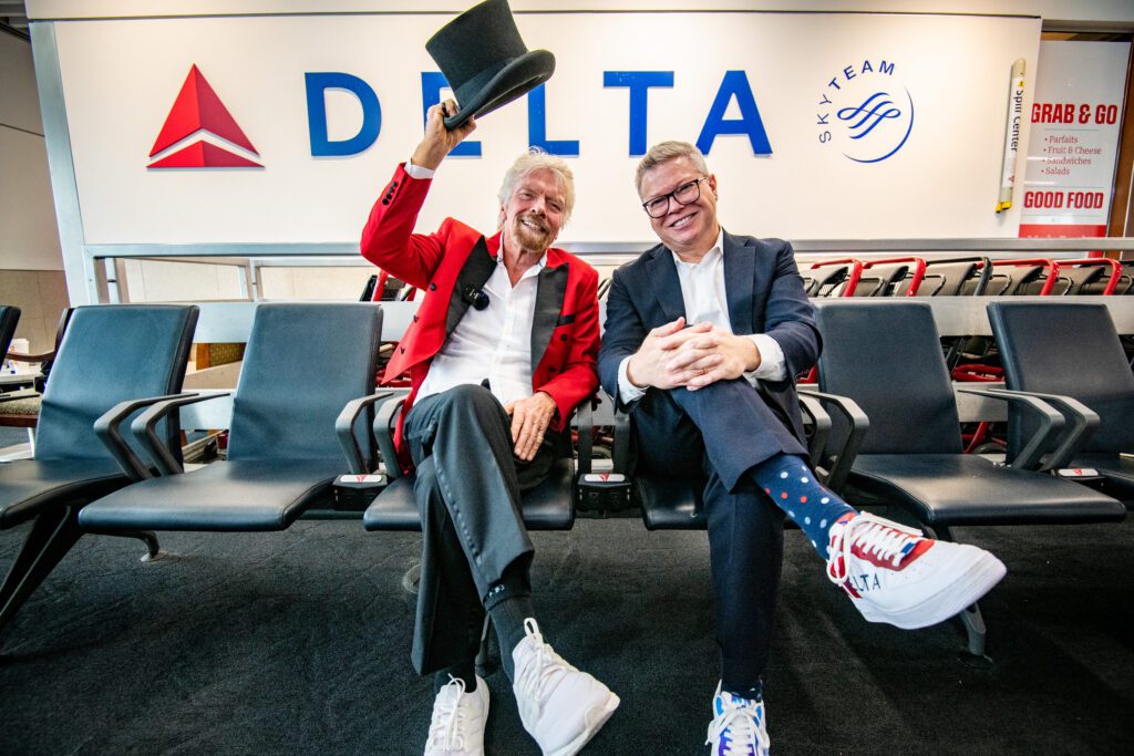 two men sitting in chairs in an airport