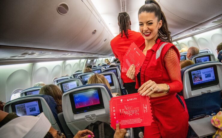 a woman in red suit standing in an airplane