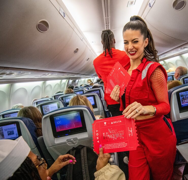a woman in red suit standing in an airplane
