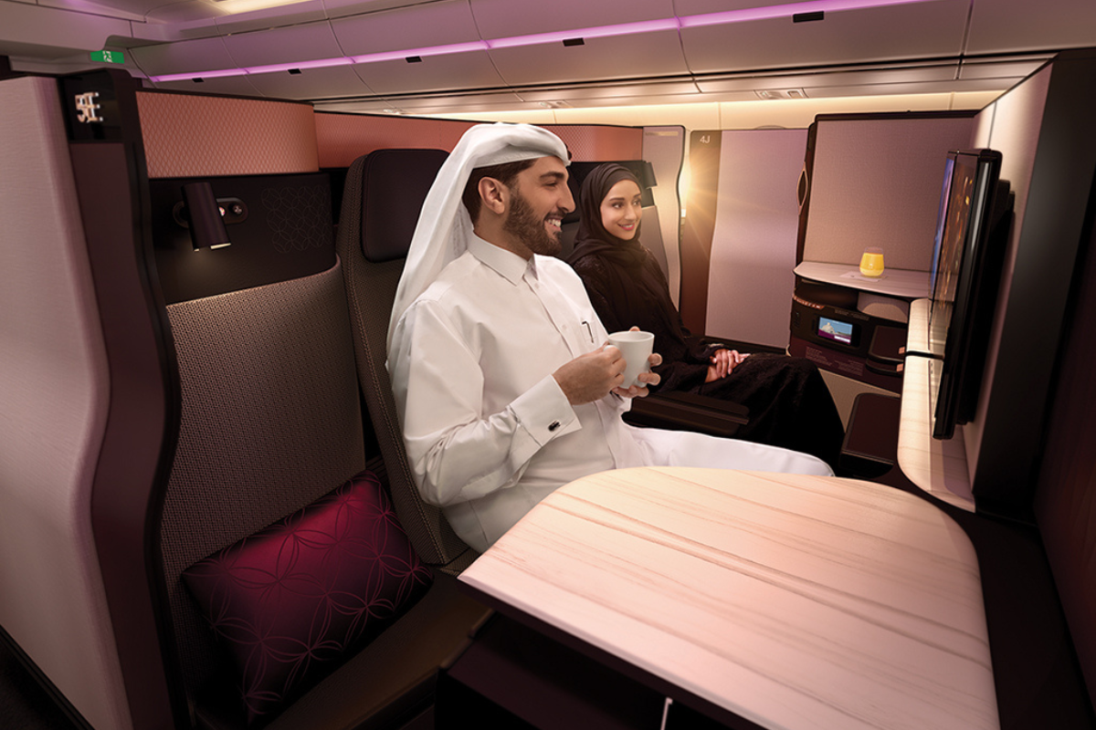 a man and woman sitting in a chair on an airplane