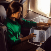 a woman sitting in an airplane with a laptop
