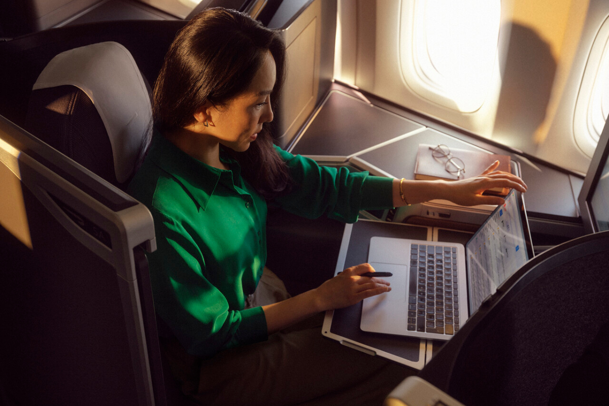 a woman sitting in an airplane with a laptop