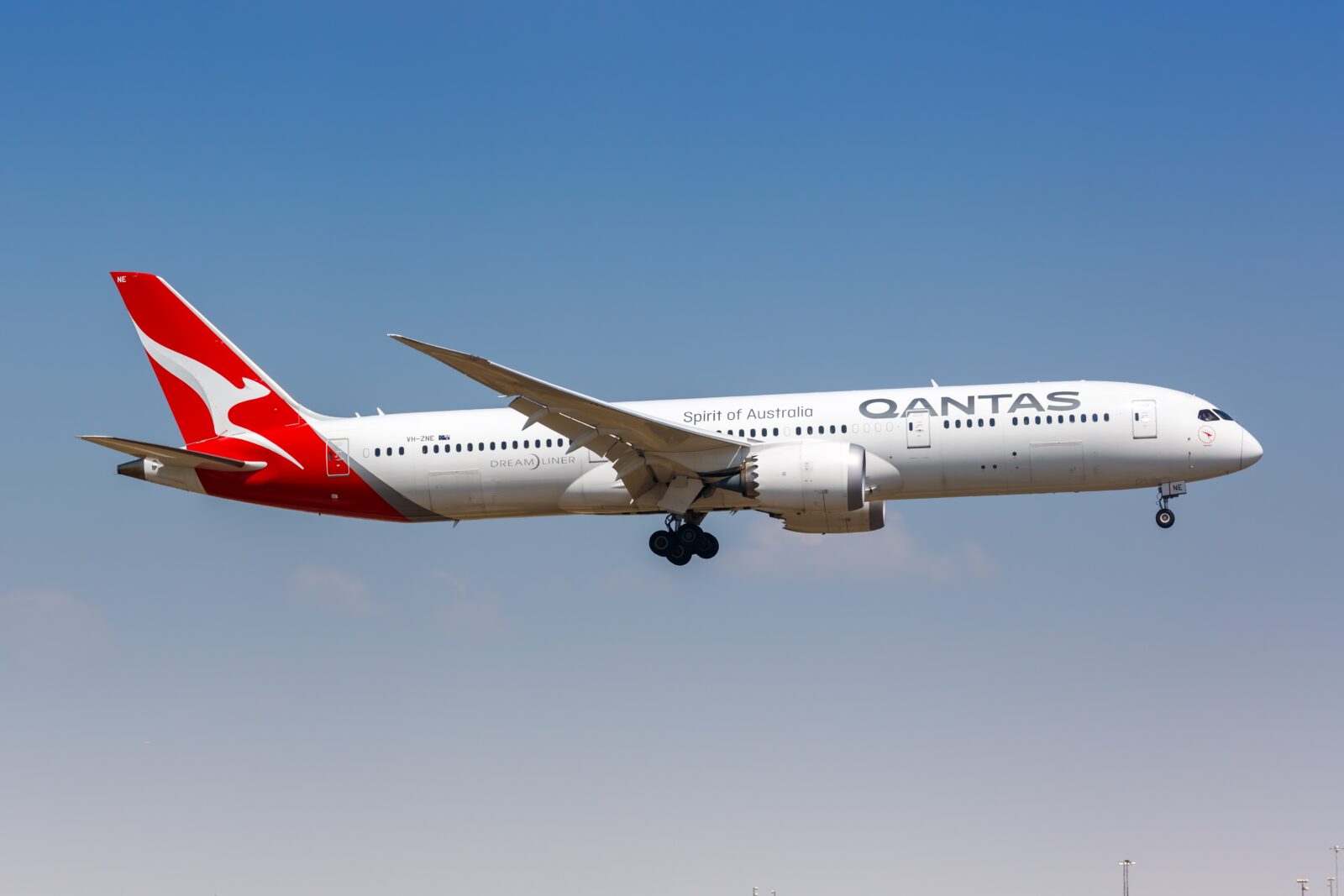 a white airplane with red and white markings flying in the sky